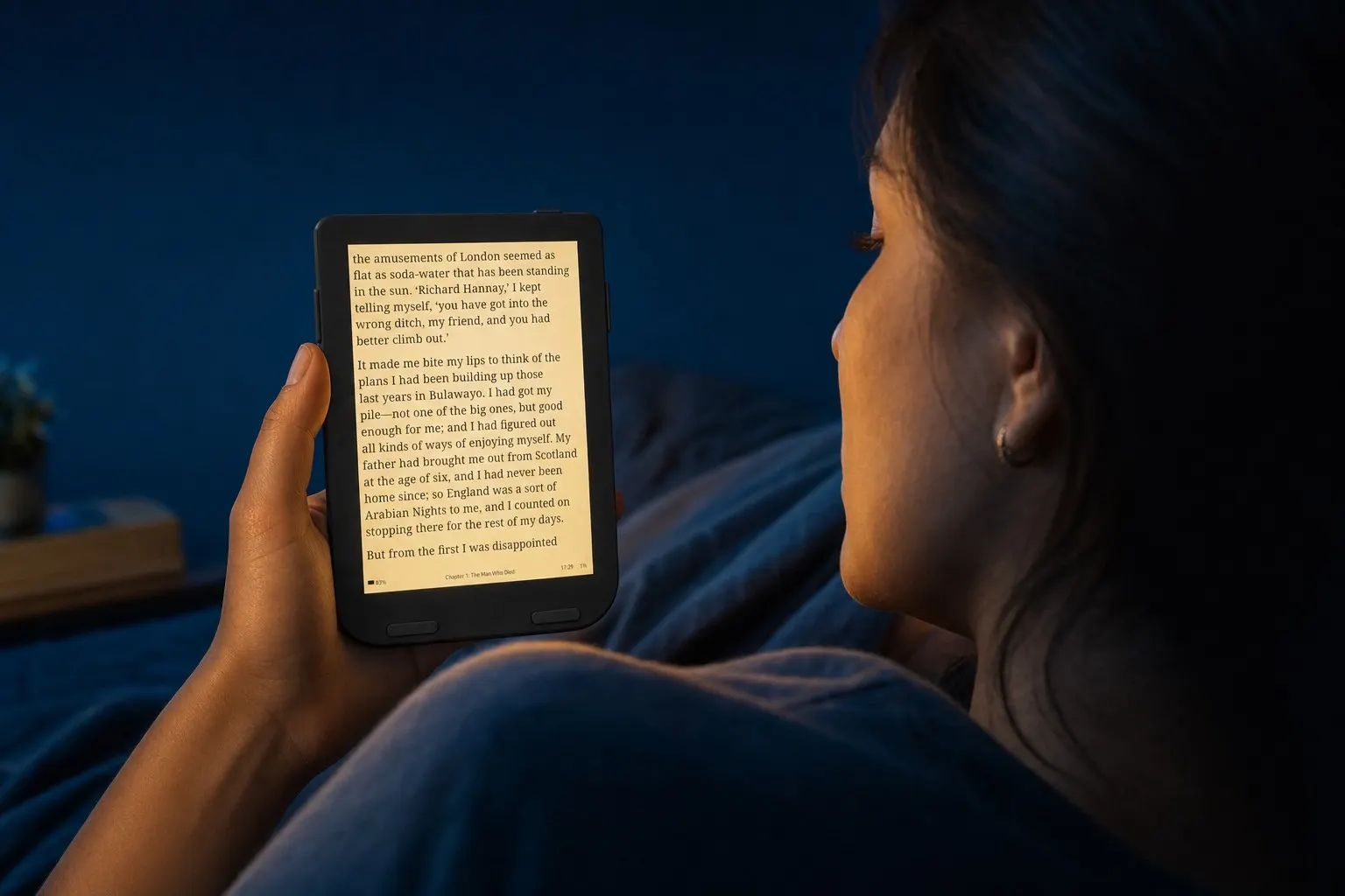 Reading a black Snug Mini in a dark bedroom with its warm front light on